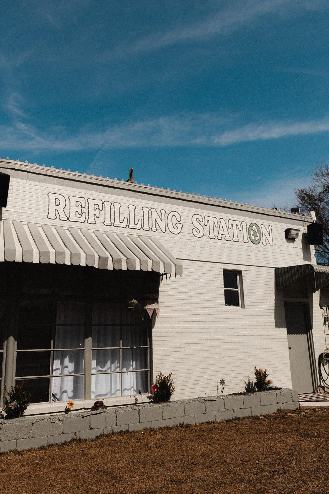 The Re-Filling Station on Main Street — white brick with REFILLING STATION lettering above the striped awning